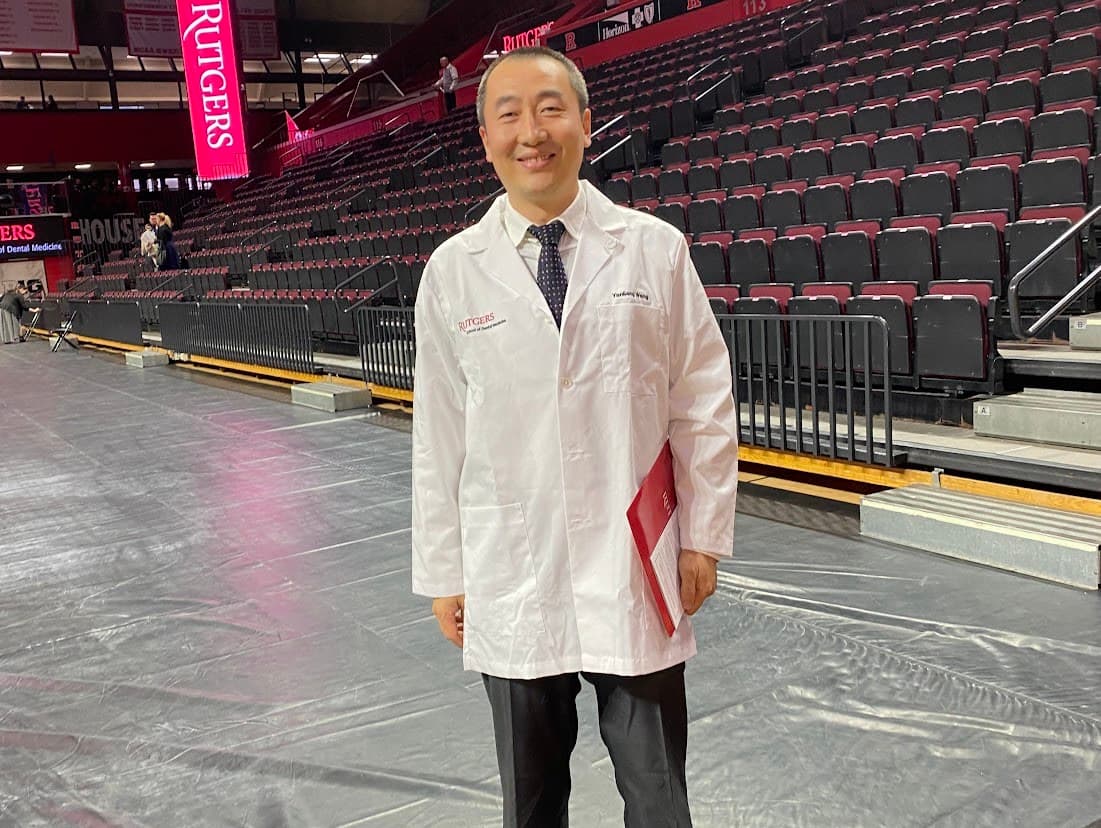 Dr. Yanliang Wang in his Rutgers School of Dental Medicine white coat